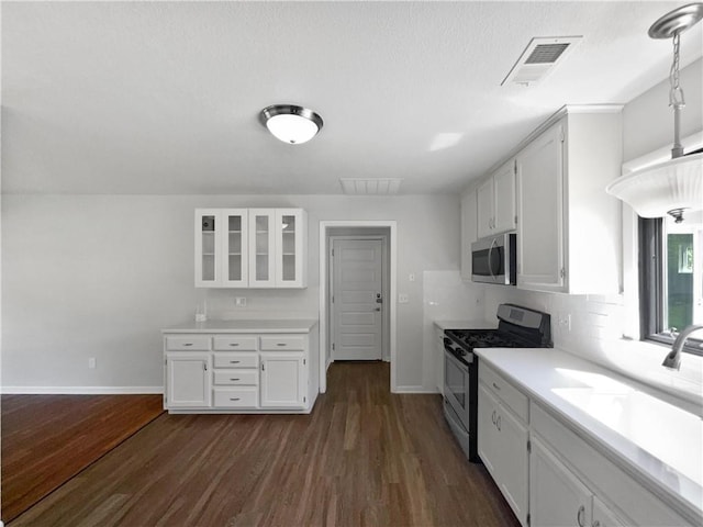 7139 Hardy St, Overland Park, KS 66204 - kitchen featuring appliances with stainless steel finishes, dark wood-type flooring, and white cabinetry