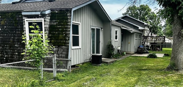 1300 S Main St, Harrisonville, MO 64701 - view of home's exterior featuring board and batten siding, roof with shingles, a deck, and a patio area