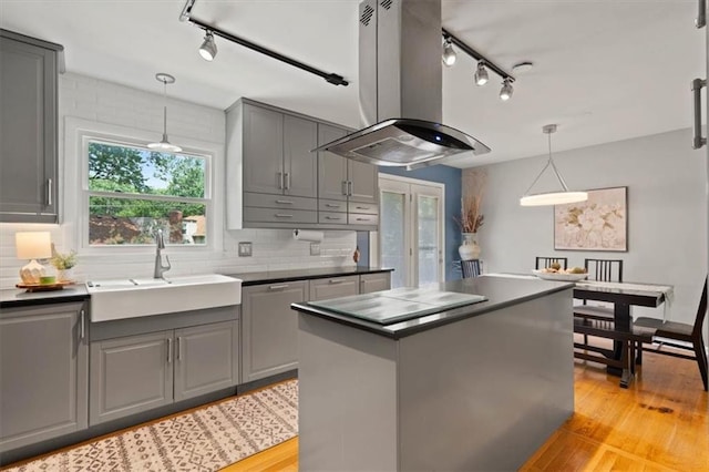 9520 Lamar Ave, Overland Park, KS 66207 - kitchen featuring rail lighting, island range hood, dark countertops, and gray cabinetry
