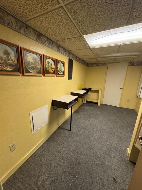 6705 E 140th Pl, Grandview, MO 64030 - rec room with dark colored carpet, a paneled ceiling, and baseboards