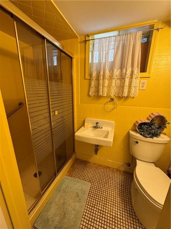 6705 E 140th Pl, Grandview, MO 64030 - full bath with toilet, a shower stall, and tile walls