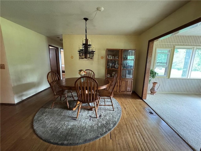 6705 E 140th Pl, Grandview, MO 64030 - dining space with a chandelier, light wood-type flooring, and a textured ceiling