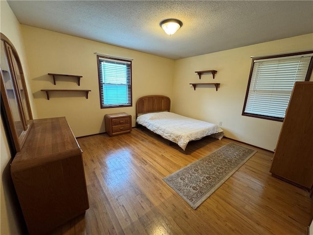 6705 E 140th Pl, Grandview, MO 64030 - bedroom with wood finished floors and a textured ceiling