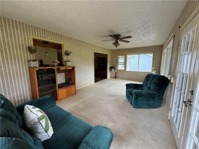 6705 E 140th Pl, Grandview, MO 64030 - carpeted living area featuring a textured ceiling, ceiling fan, wallpapered walls, and french doors