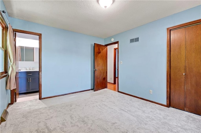7608 N Serene Ave, Kansas City, MO 64152 - unfurnished bedroom with a closet, baseboards, light carpet, a sink, and a textured ceiling