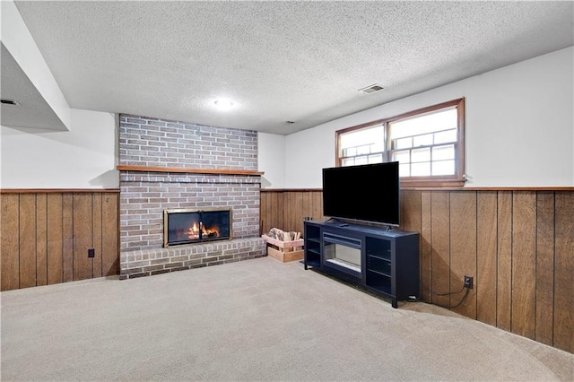 7608 N Serene Ave, Kansas City, MO 64152 - living area with wainscoting, wooden walls, a textured ceiling, a fireplace, and carpet floors