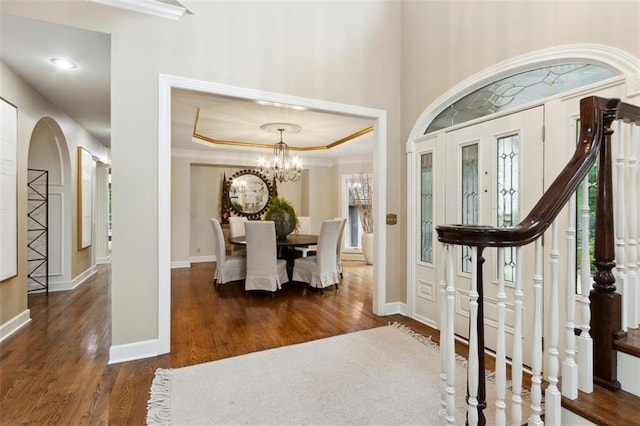 5403 Windsor Ln, Fairway, KS 66205 - foyer entrance with crown molding, wood finished floors, arched walkways, a chandelier, and baseboards