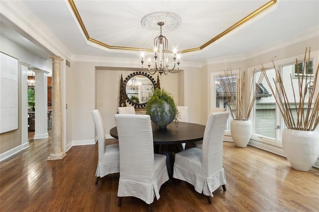 5403 Windsor Ln, Fairway, KS 66205 - dining room featuring decorative columns, a raised ceiling, ornamental molding, a chandelier, and wood finished floors
