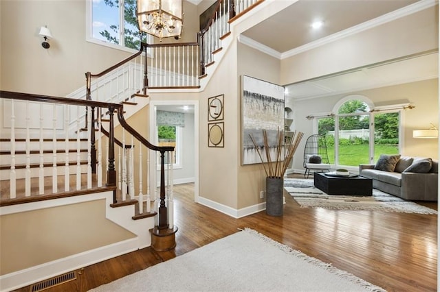 5403 Windsor Ln, Fairway, KS 66205 - stairway featuring crown molding, wood finished floors, plenty of natural light, a chandelier, and baseboards