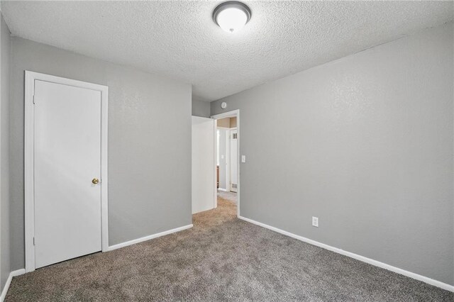 5609 E 101st St, Kansas City, MO 64137 - unfurnished bedroom with carpet flooring, a textured ceiling, and baseboards