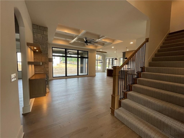 17000 Rosehill St, Overland Park, KS 66221 - stairway with coffered ceiling, a ceiling fan, wood finished floors, beam ceiling, and arched walkways