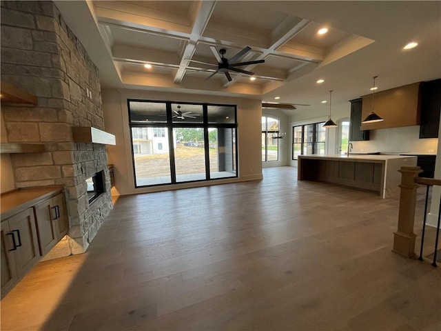 17000 Rosehill St, Overland Park, KS 66221 - unfurnished living room with ceiling fan, coffered ceiling, a stone fireplace, light wood-style flooring, and beamed ceiling