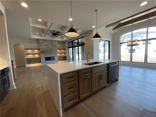 17000 Rosehill St, Overland Park, KS 66221 - kitchen featuring stainless steel dishwasher, ceiling fan, a stone fireplace, open floor plan, and dark wood-type flooring