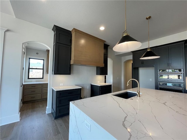 17000 Rosehill St, Overland Park, KS 66221 - kitchen featuring arched walkways, stainless steel oven, light stone countertops, wood finished floors, and oven