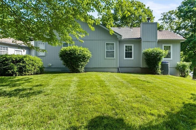 3000 Cedar Crest Dr, Independence, MO 64057 - back of property with a lawn, a chimney, cooling unit, and a shingled roof