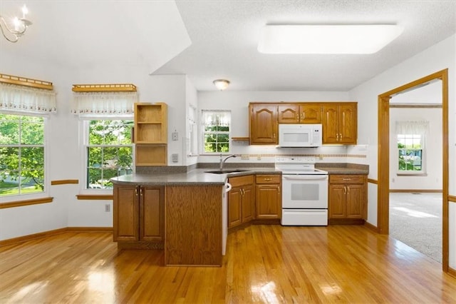 3000 Cedar Crest Dr, Independence, MO 64057 - kitchen featuring white appliances, brown cabinets, light wood-style floors, a sink, and dark countertops