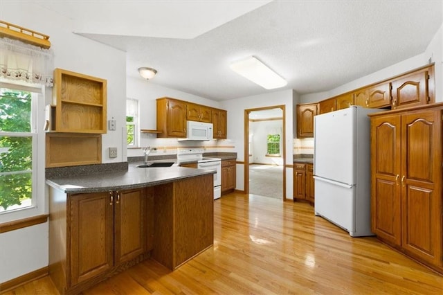 3000 Cedar Crest Dr, Independence, MO 64057 - kitchen with white appliances, a peninsula, a sink, light wood finished floors, and a textured ceiling