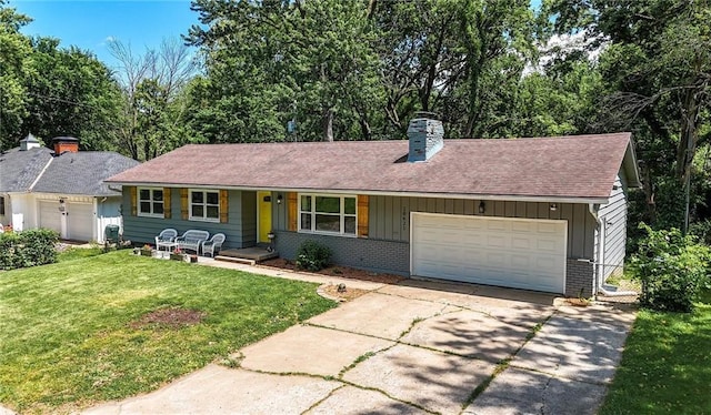 10621 E 32nd St, Independence, MO 64052 - ranch-style home featuring board and batten siding, a chimney, a front yard, an attached garage, and driveway