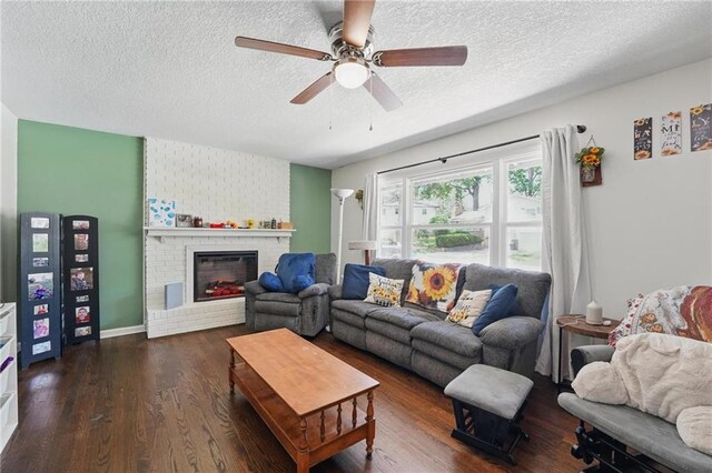 10621 E 32nd St, Independence, MO 64052 - living room with a textured ceiling, dark wood-type flooring, a ceiling fan, and a brick fireplace