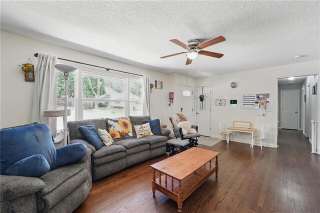 10621 E 32nd St, Independence, MO 64052 - living room with a ceiling fan, a textured ceiling, dark wood-style flooring, and baseboards