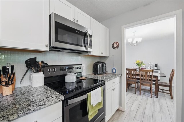 10621 E 32nd St, Independence, MO 64052 - kitchen featuring appliances with stainless steel finishes, light stone counters, and tasteful backsplash