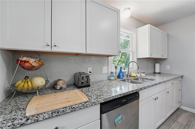 10621 E 32nd St, Independence, MO 64052 - kitchen with dishwasher, a sink, tasteful backsplash, white cabinetry, and light stone counters