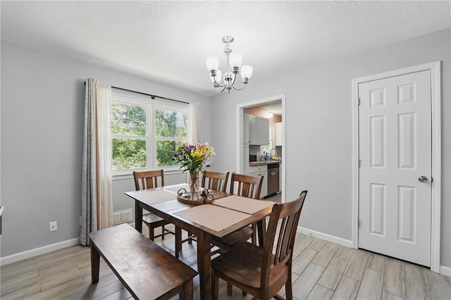 10621 E 32nd St, Independence, MO 64052 - dining space featuring a chandelier, light wood-style flooring, baseboards, and a textured ceiling