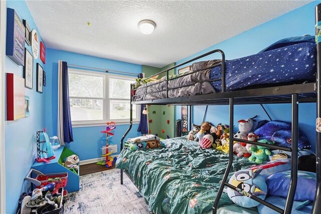 10621 E 32nd St, Independence, MO 64052 - bedroom featuring wood finished floors, a textured ceiling, and baseboards