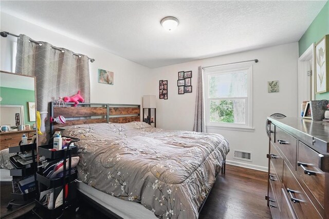 10621 E 32nd St, Independence, MO 64052 - bedroom with dark wood finished floors, baseboards, and a textured ceiling