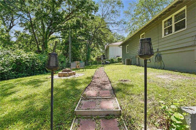 10621 E 32nd St, Independence, MO 64052 - view of green lawn featuring a fire pit and central AC unit