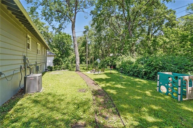 10621 E 32nd St, Independence, MO 64052 - view of grassy yard with central air condition unit and view of wooded area