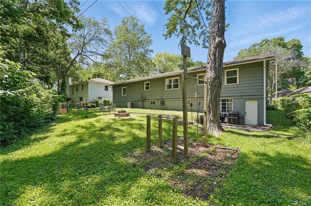 10621 E 32nd St, Independence, MO 64052 - back of house featuring an outdoor fire pit and a yard