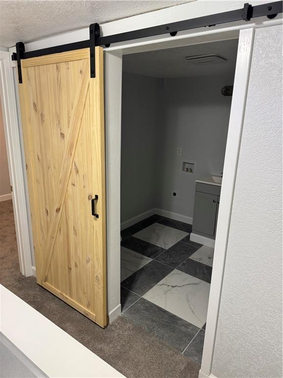 116 N Home St, Independence, MO 64053 - washroom with a barn door, hookup for a washing machine, marble finish flooring, and baseboards