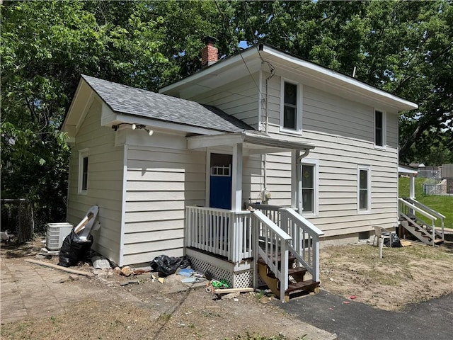 116 N Home St, Independence, MO 64053 - view of front of property featuring a chimney, a shingled roof, and central air condition unit
