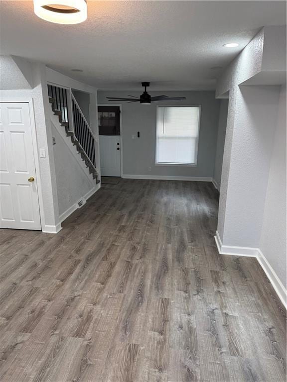 116 N Home St, Independence, MO 64053 - unfurnished living room with baseboards, ceiling fan, stairs, wood finished floors, and a textured ceiling