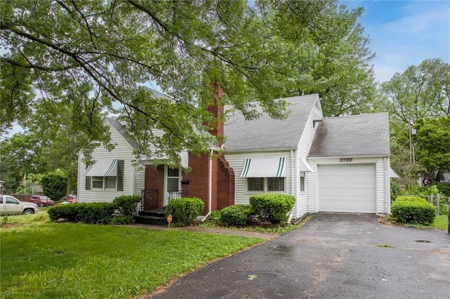 2738 S Crysler Ave, Independence, MO 64052 - view of front of home with an attached garage, a front yard, driveway, a shingled roof, and a chimney