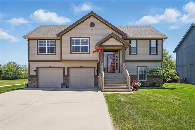 1037 NW 91st Ter, Kansas City, MO 64155 - bi-level home with an attached garage, cooling unit, driveway, a front lawn, and stone siding