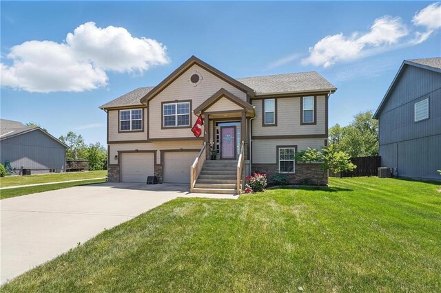 1037 NW 91st Ter, Kansas City, MO 64155 - raised ranch featuring a garage, stone siding, concrete driveway, and cooling unit