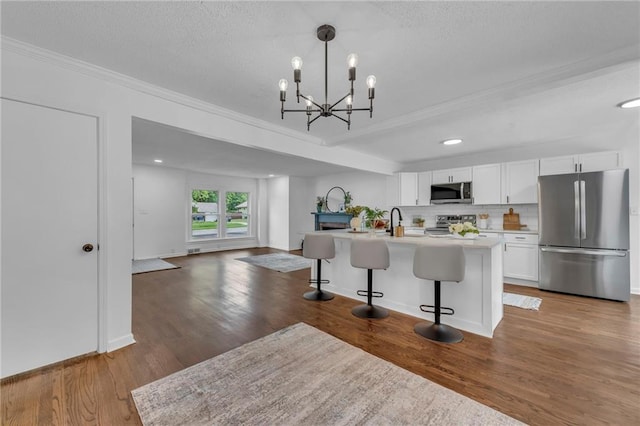 706 W Cedar St, Olathe, KS 66061 - kitchen with stainless steel appliances, crown molding, white cabinets, a breakfast bar area, and light countertops