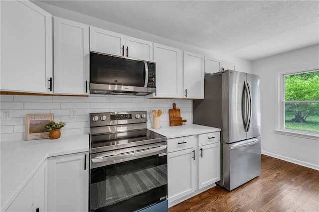 706 W Cedar St, Olathe, KS 66061 - kitchen with stainless steel appliances, tasteful backsplash, light countertops, dark wood-style flooring, and white cabinetry