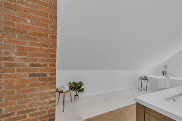 706 W Cedar St, Olathe, KS 66061 - bathroom with lofted ceiling, vanity, and a freestanding tub
