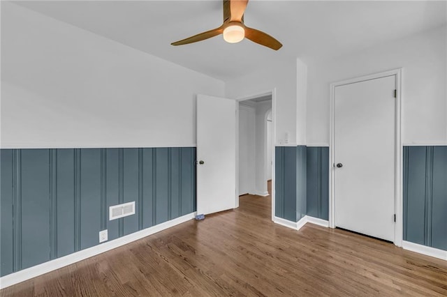 706 W Cedar St, Olathe, KS 66061 - empty room featuring wood finished floors, ceiling fan, and wainscoting