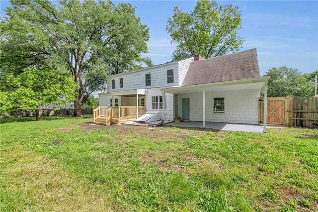 706 W Cedar St, Olathe, KS 66061 - back of house featuring a patio, a wooden deck, a shingled roof, a chimney, and a gate