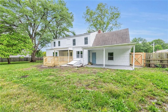 706 W Cedar St, Olathe, KS 66061 - rear view of house with a patio area, a wooden deck, a shingled roof, a chimney, and a gate