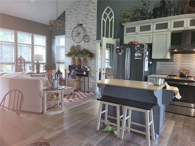 1154 SE 364p Rd, Clinton, MO 64735 - kitchen featuring ventilation hood, appliances with stainless steel finishes, high vaulted ceiling, light countertops, and tasteful backsplash