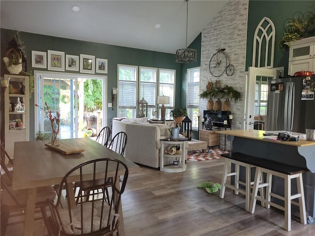 1154 SE 364p Rd, Clinton, MO 64735 - dining room with wood finished floors, high vaulted ceiling, a chandelier, and a fireplace