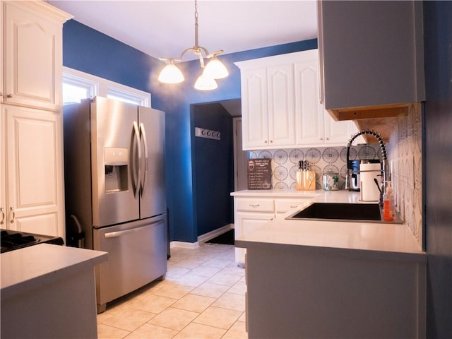 3812 Anderson Ave, Kansas City, MO 64132 - kitchen with stainless steel fridge with ice dispenser, a sink, backsplash, a chandelier, and light tile patterned flooring