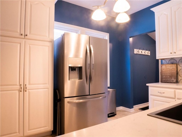 3812 Anderson Ave, Kansas City, MO 64132 - kitchen featuring stainless steel fridge with ice dispenser, light countertops, white cabinetry, and baseboards