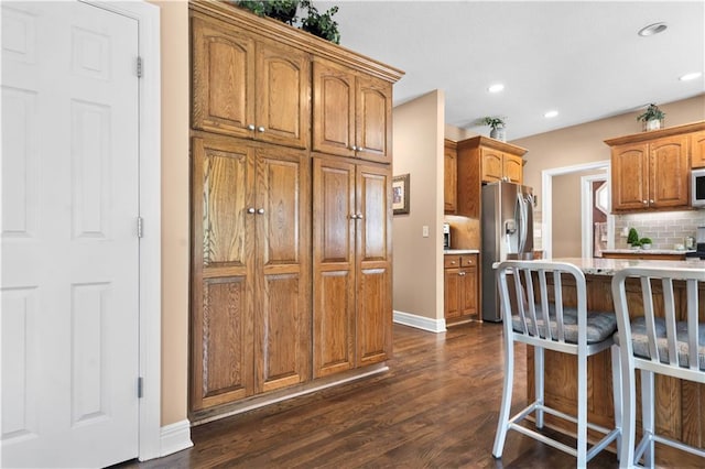 15801 Parkhill St, Overland Park, KS 66221 - kitchen featuring appliances with stainless steel finishes, dark wood-type flooring, baseboards, decorative backsplash, and recessed lighting