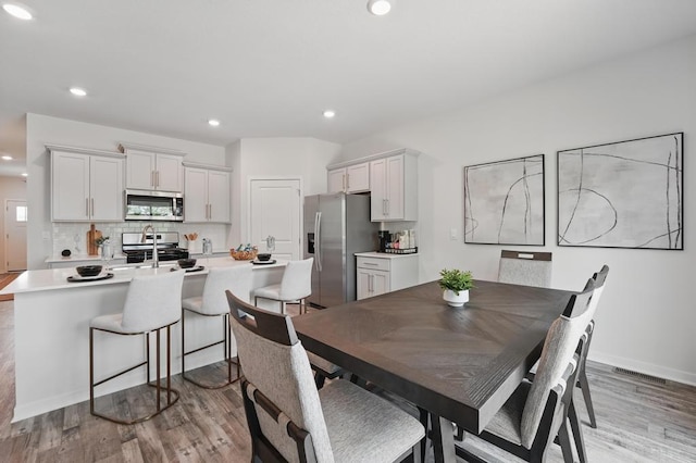 2208 Crestview Pl, Raymore, MO 64083 - dining room with light wood-style floors, recessed lighting, and baseboards